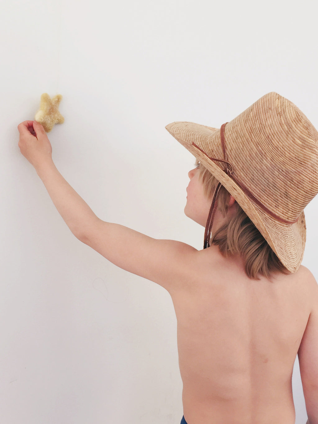 boy holding a star with cowboy hat 